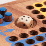 Gros plan sur les pions bleus et le dé en bois