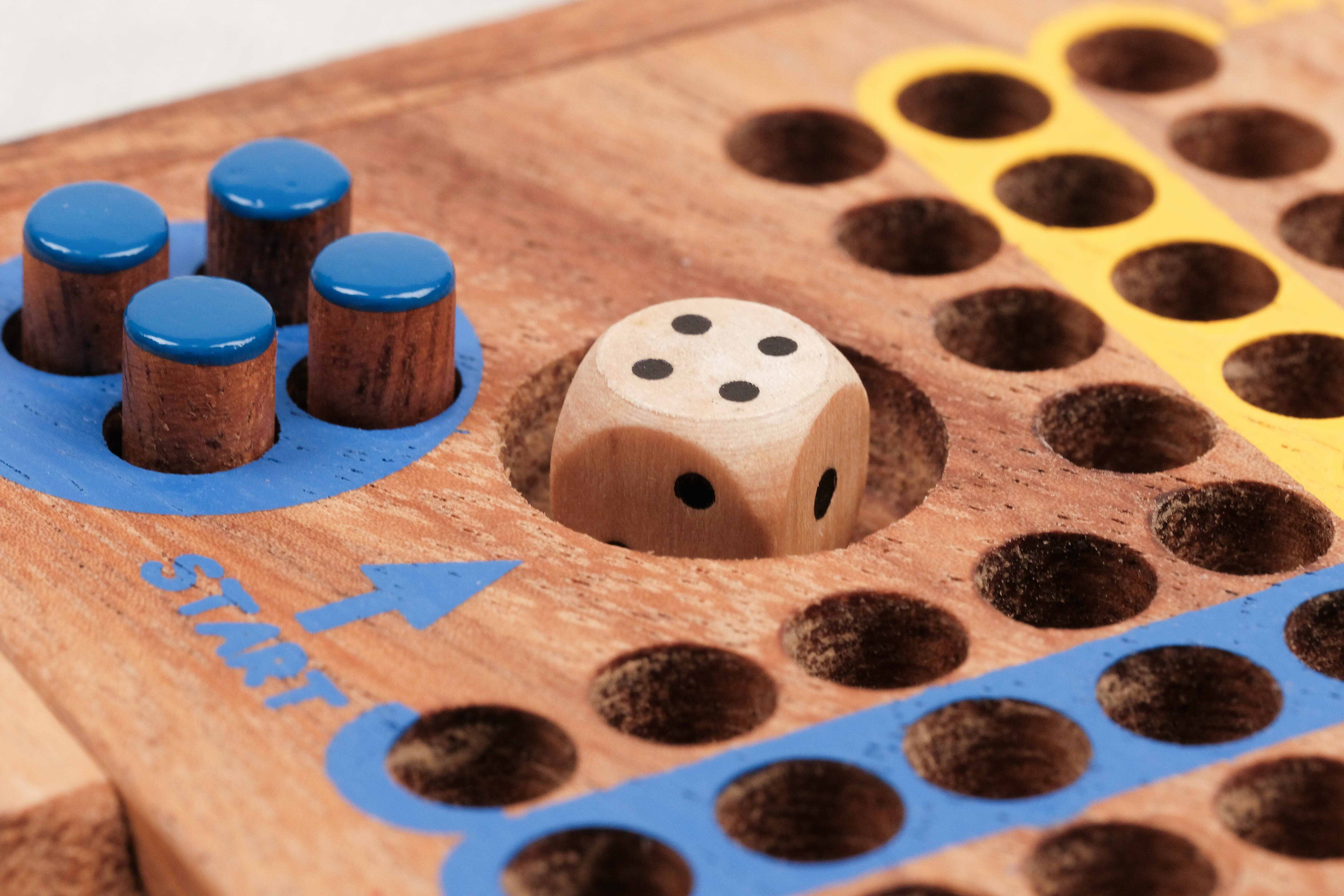 Gros plan sur les pions bleus et le dé en bois
