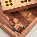 Coffret en bois ouvert avec pions et rangement intégré