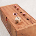 Vue inclinée du jeu en bois avec le dé et les pions sur le couvercle