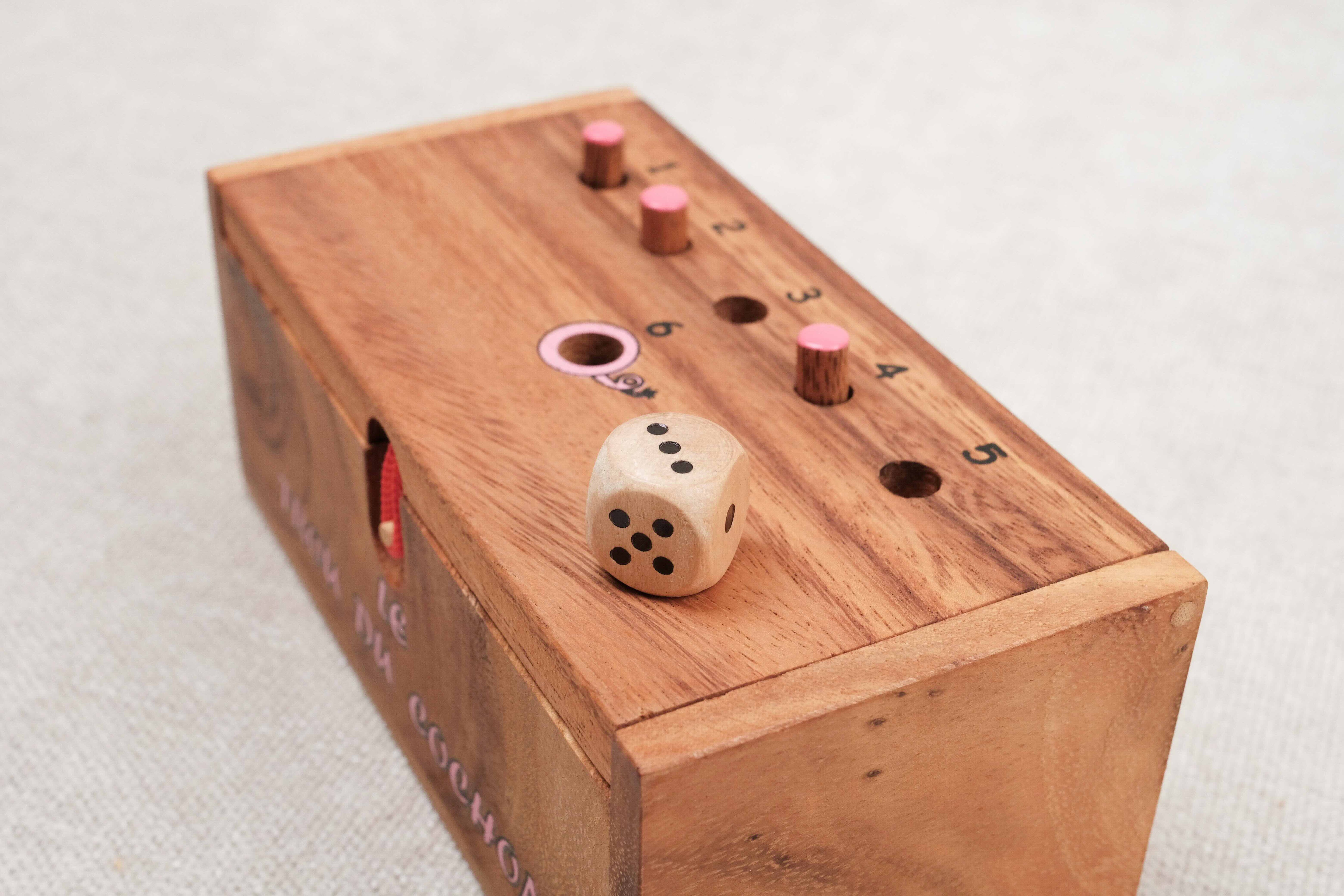 Vue inclinée du jeu en bois avec le dé et les pions sur le couvercle