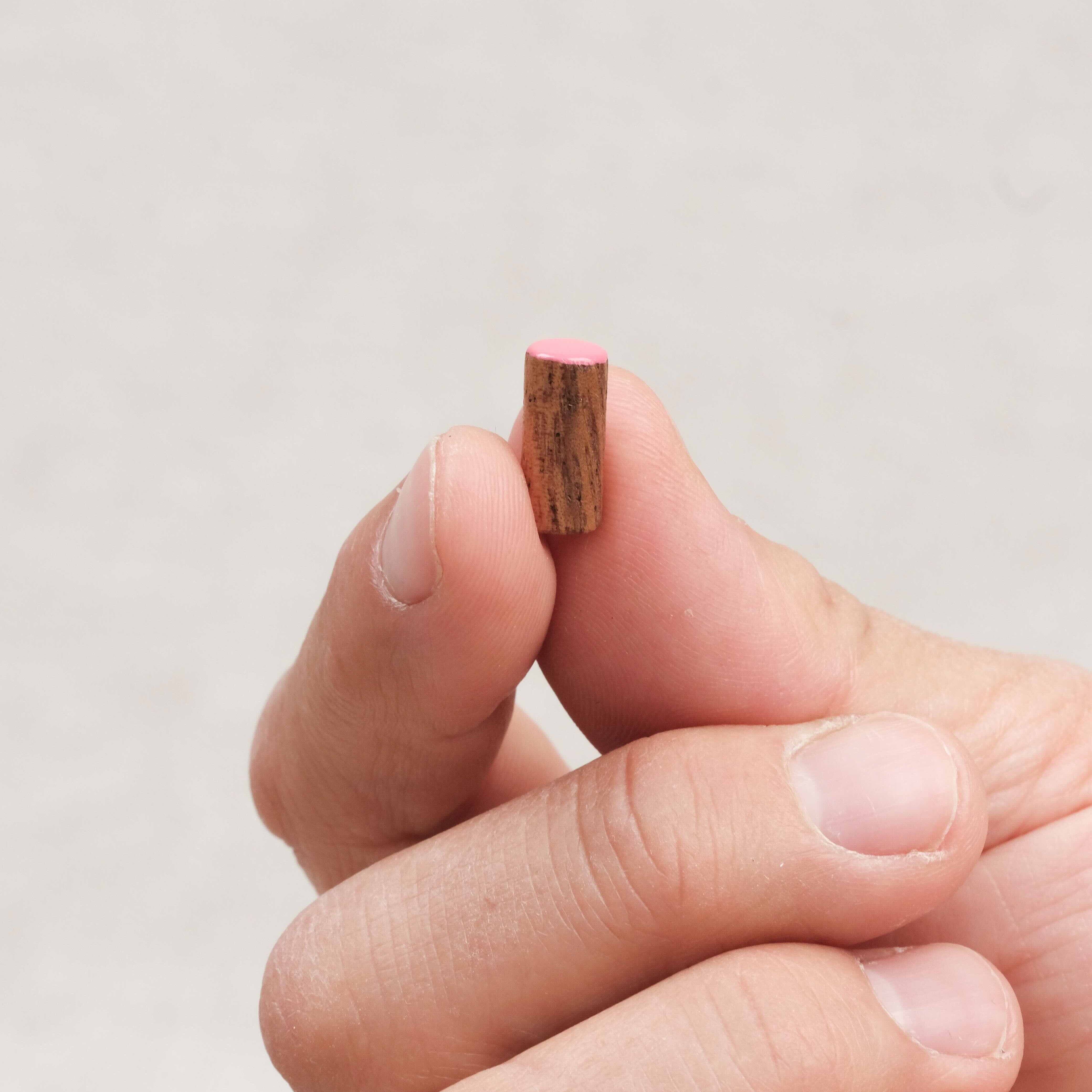 Détail d’une queue de cochon tenue entre deux doigts