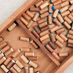 Pions en bois colorés rangés dans le coffret en bois d'acacia