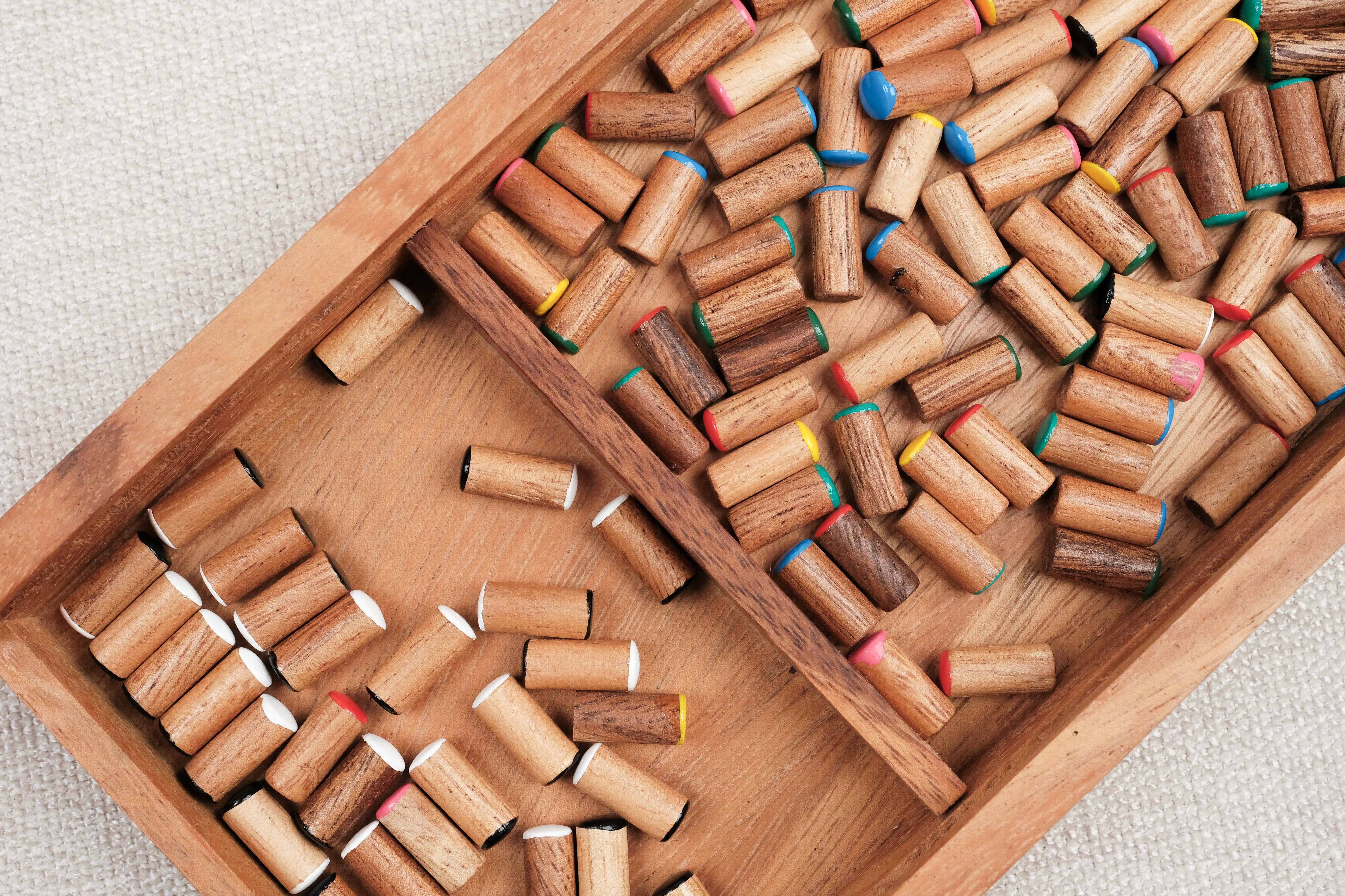 Pions en bois colorés rangés dans le coffret en bois d'acacia