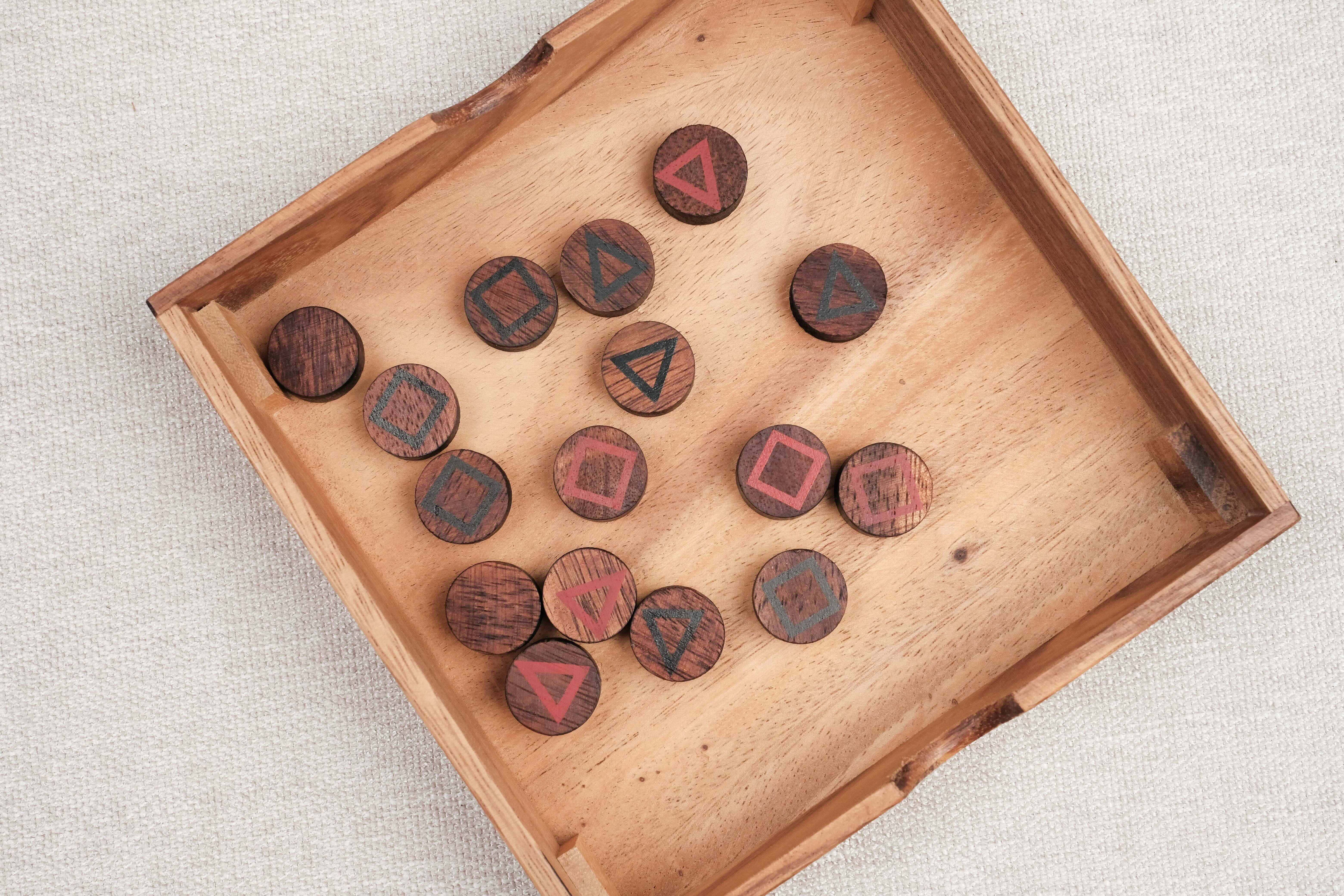 Ensemble des pions du Mystrio mélangés dans leur boîte en bois.