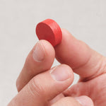 Gros plan sur un pion en bois rond du jeu Funky Fruity.