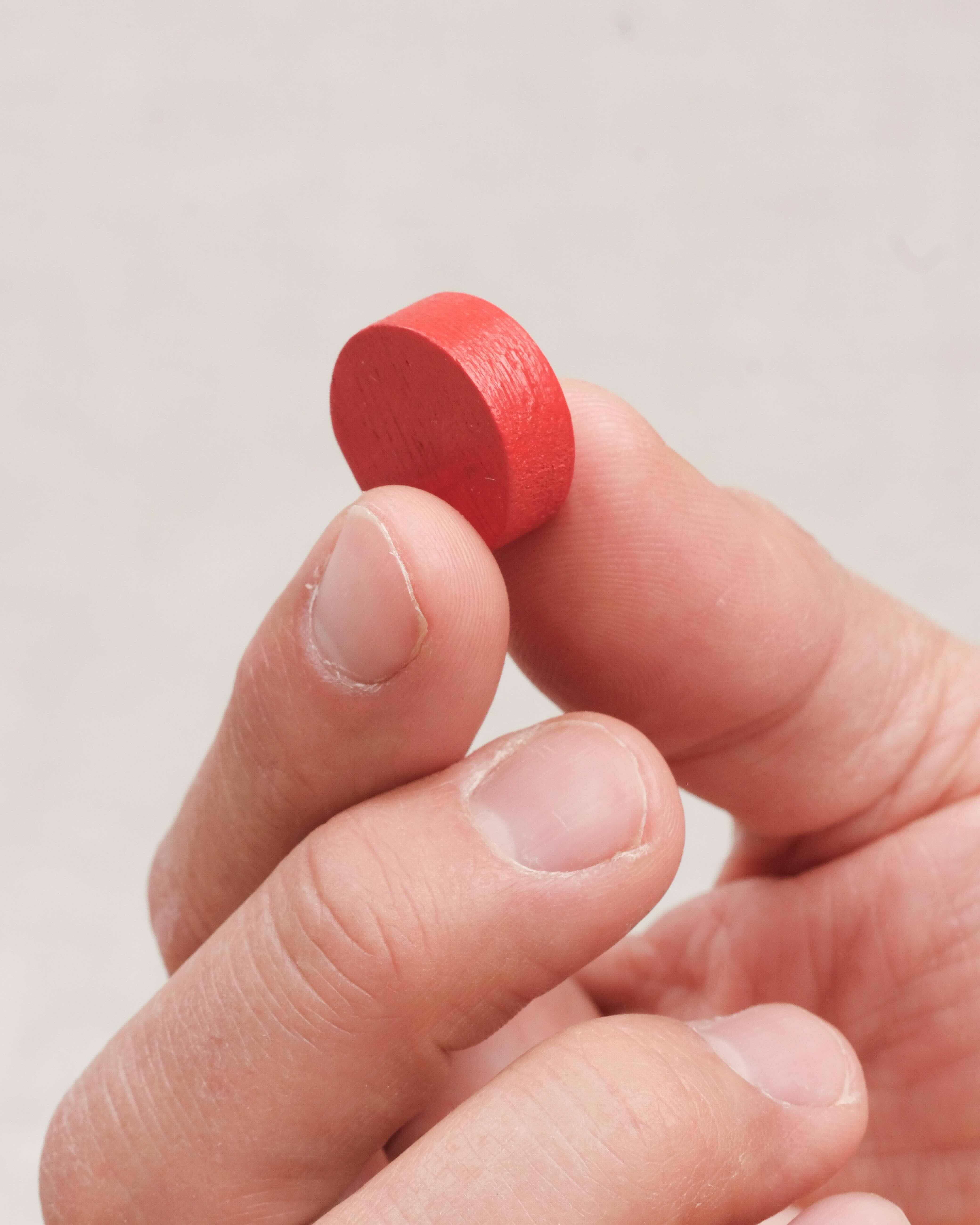 Gros plan sur un pion en bois rond du jeu Funky Fruity.