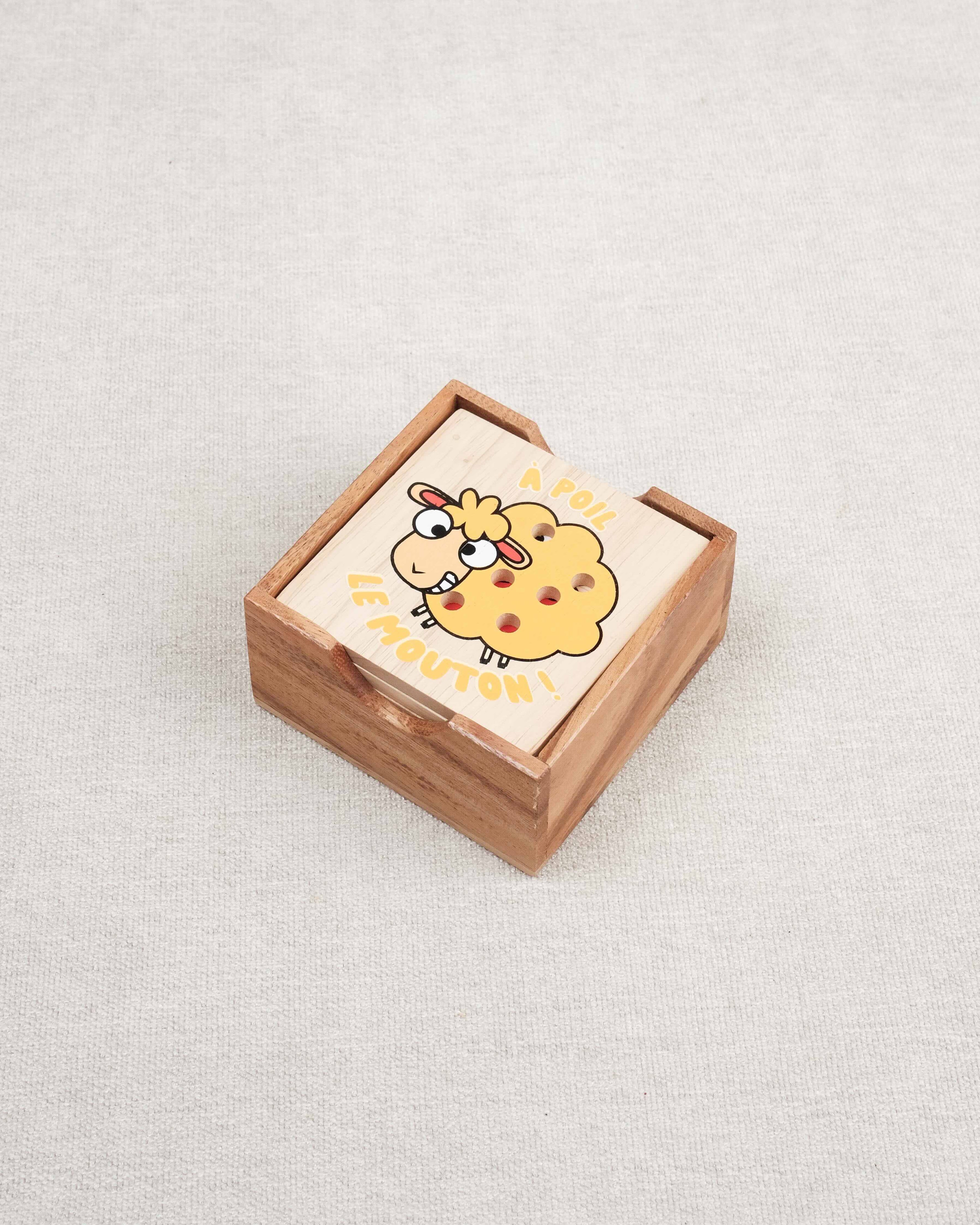 Plateau en bois du jeu À Poil le Mouton avec coffret fermé et mouton jaune illustré.