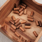 Pions en bois dans coffret du jeu À Poil le Mouton.