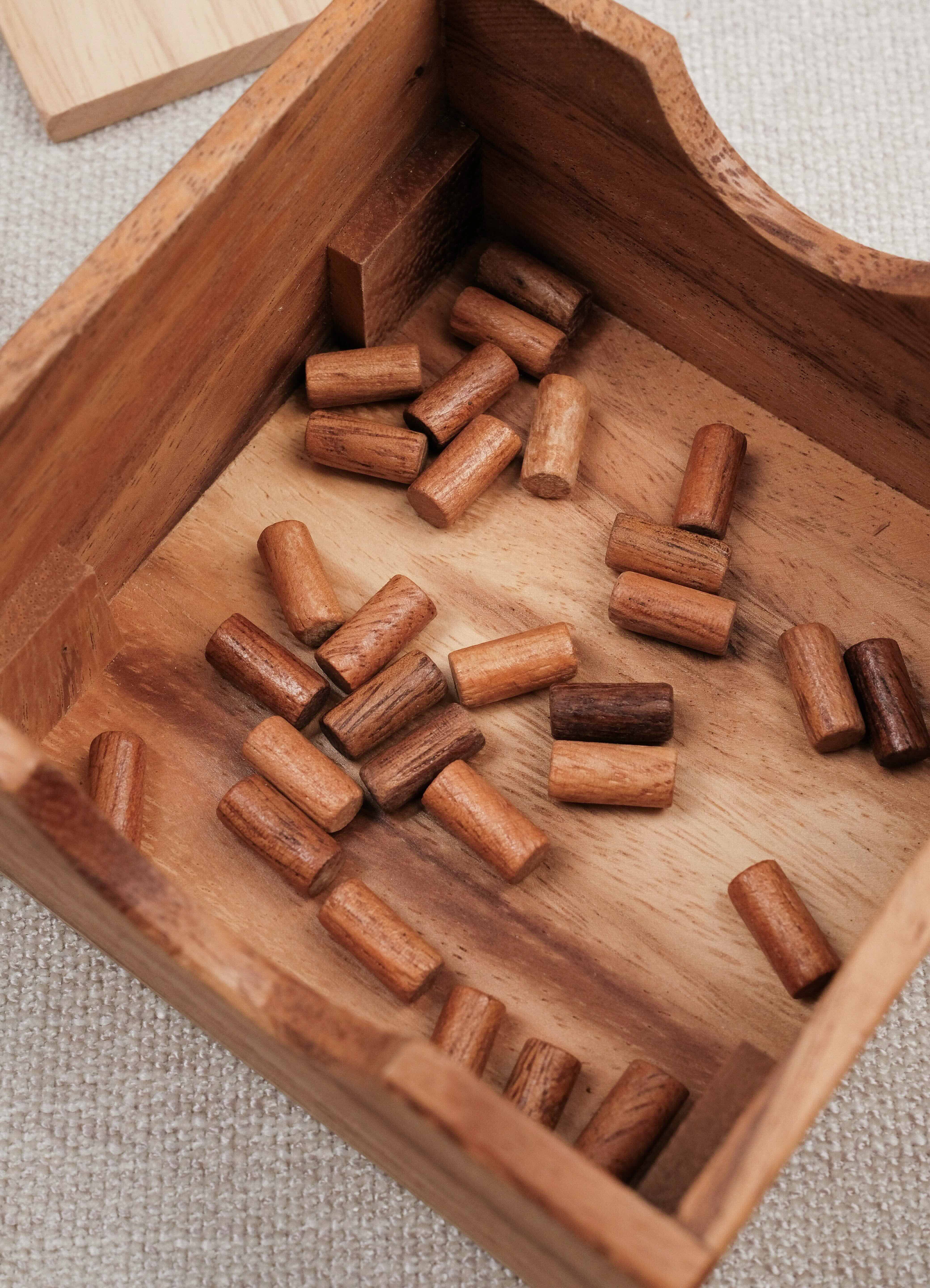 Pions en bois dans coffret du jeu À Poil le Mouton.