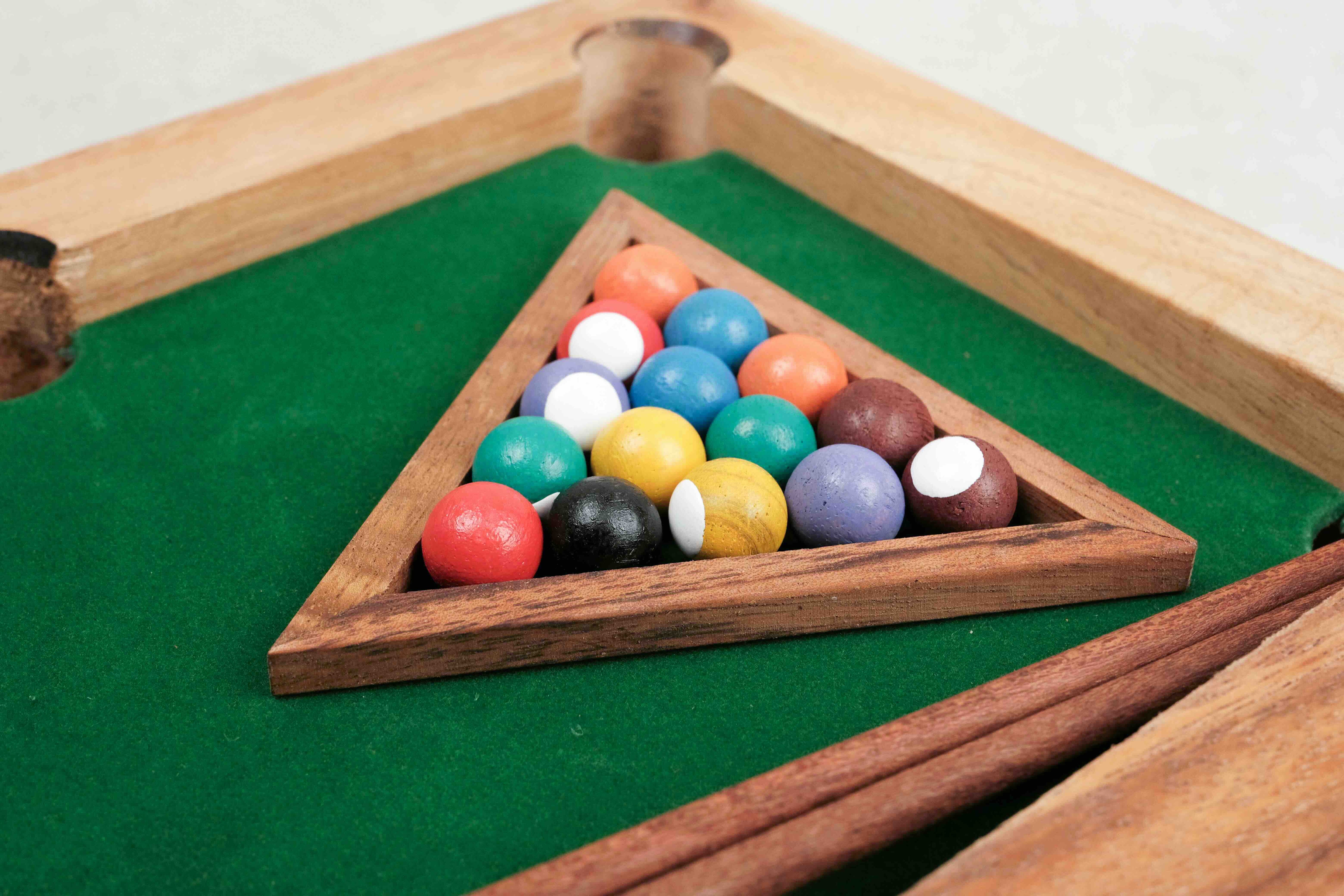 Triangle en bois rempli de boules colorées prêtes à jouer au mini billard