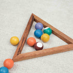 Gros plan sur les boules colorées du mini billard en bois avec triangle en bois sur fond blanc