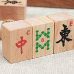 Trois tuiles de Mah-Jong et dés en bois posés sur une table