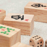 gros plan sur les tuiles de Mah-Jong et dés en bois posés sur une table
