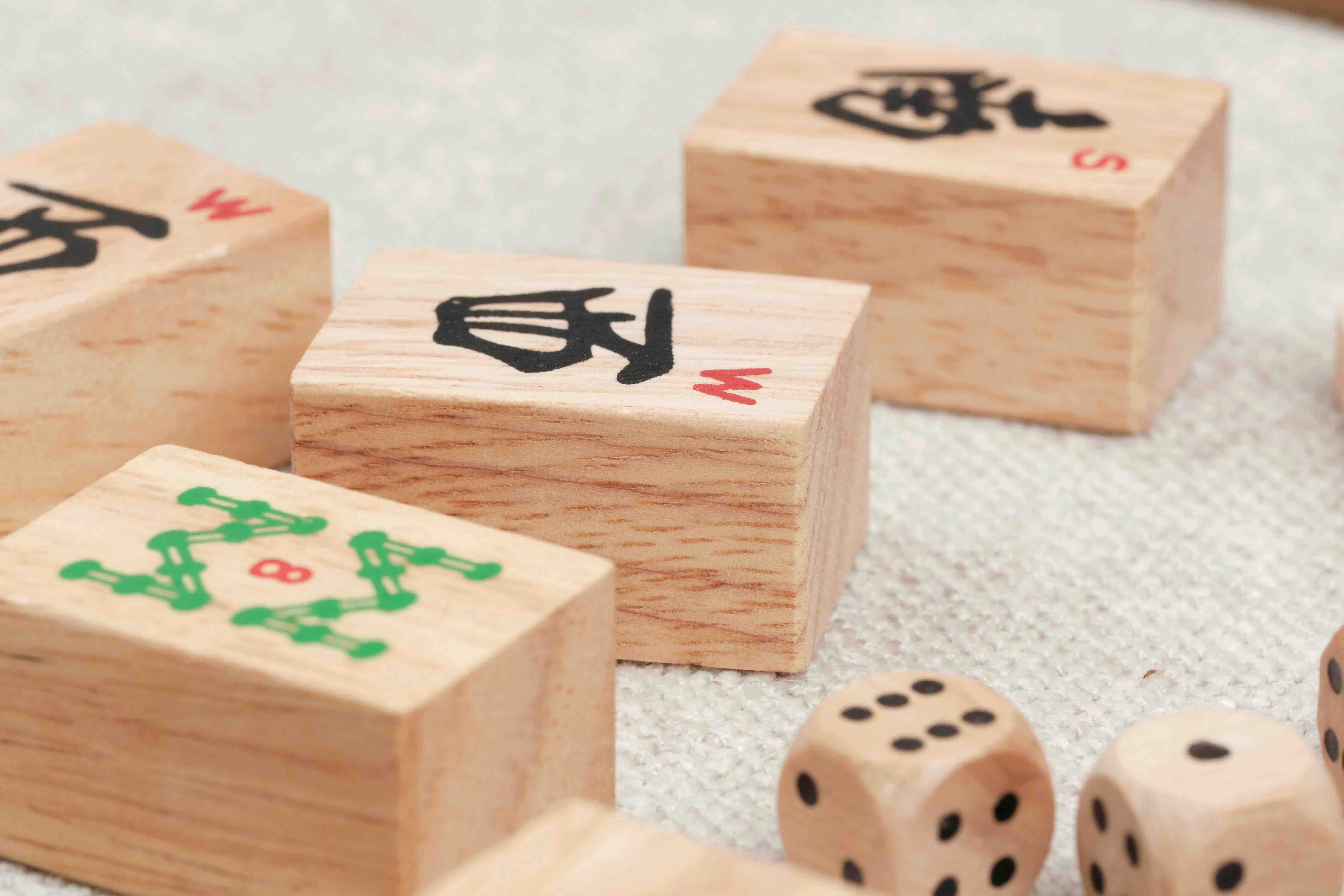 gros plan sur les tuiles de Mah-Jong et dés en bois posés sur une table