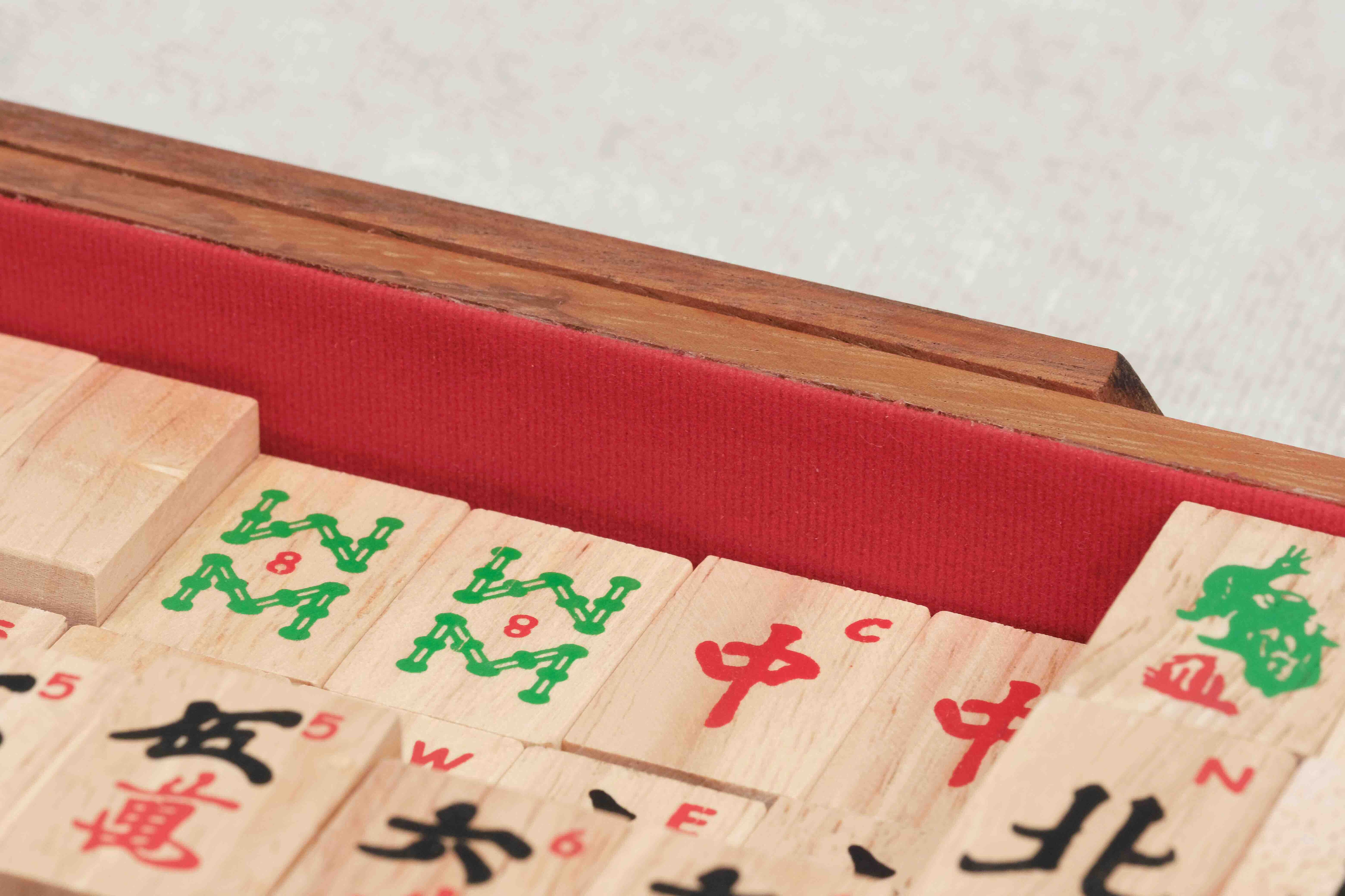 Gros plan sur les tuiles et l’intérieur feutré rouge du coffret