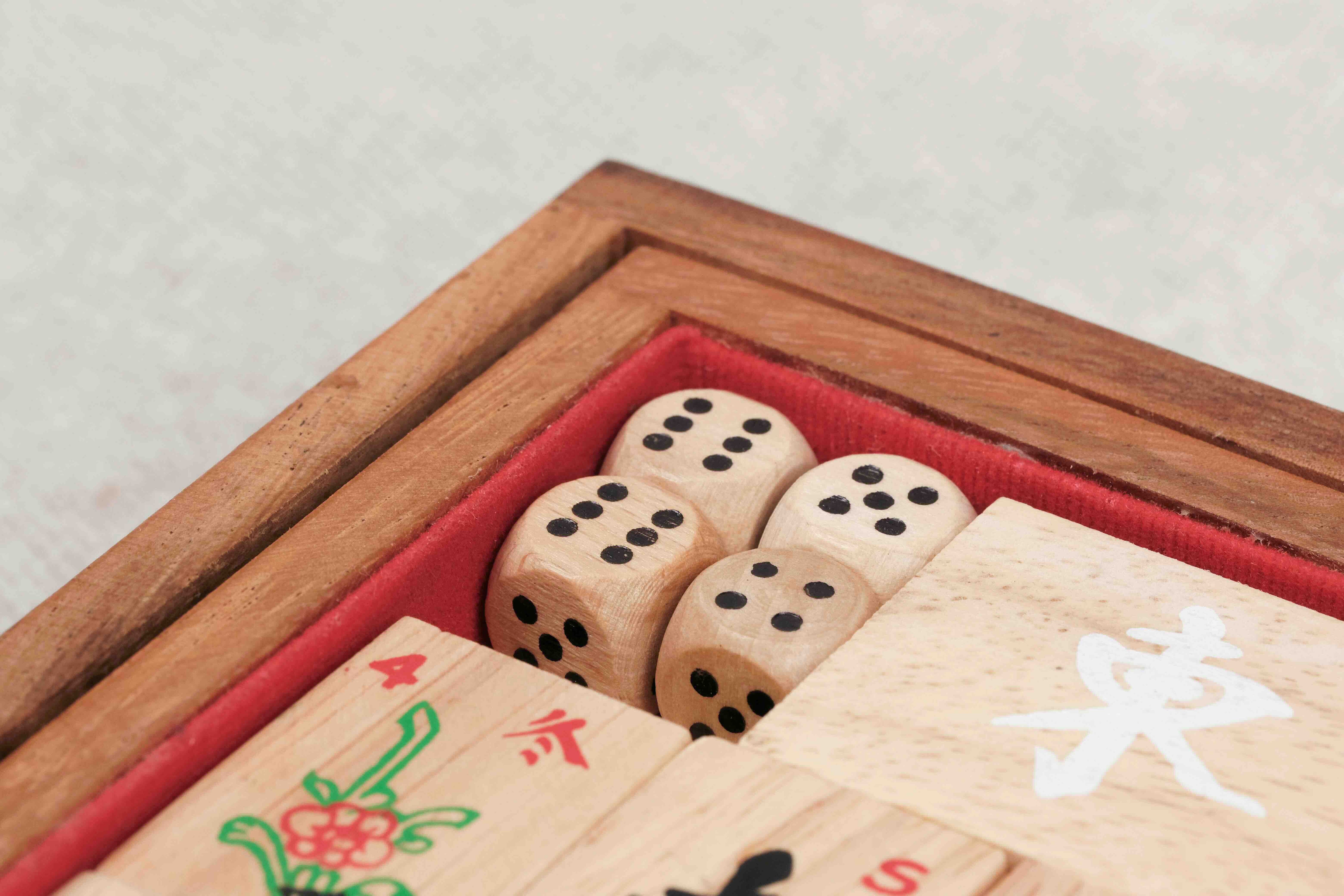 Gros plan sur les dés et l’intérieur feutré rouge du coffret en bois