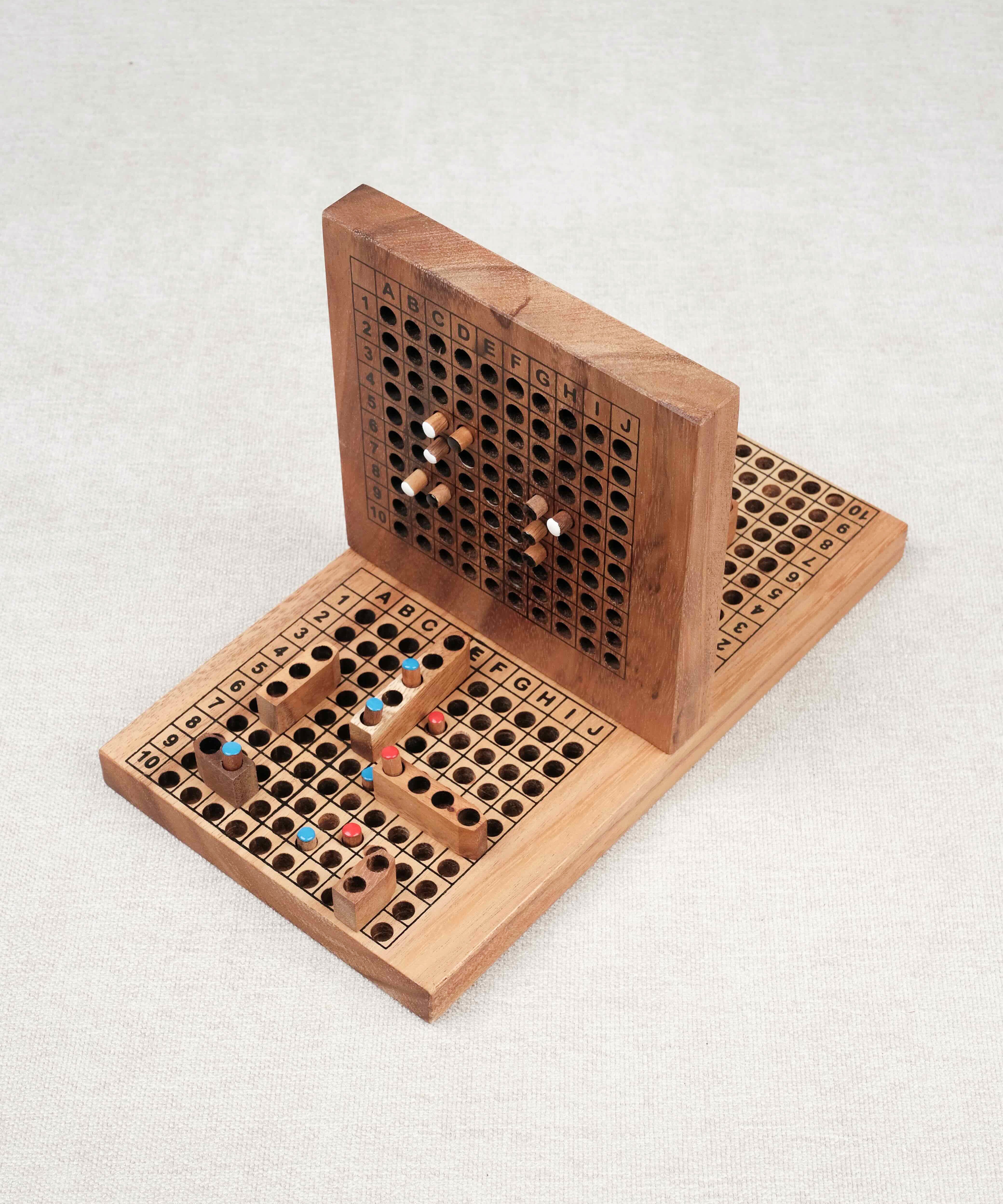 Plateau de bataille navale en bois ouvert avec pions colorés insérés