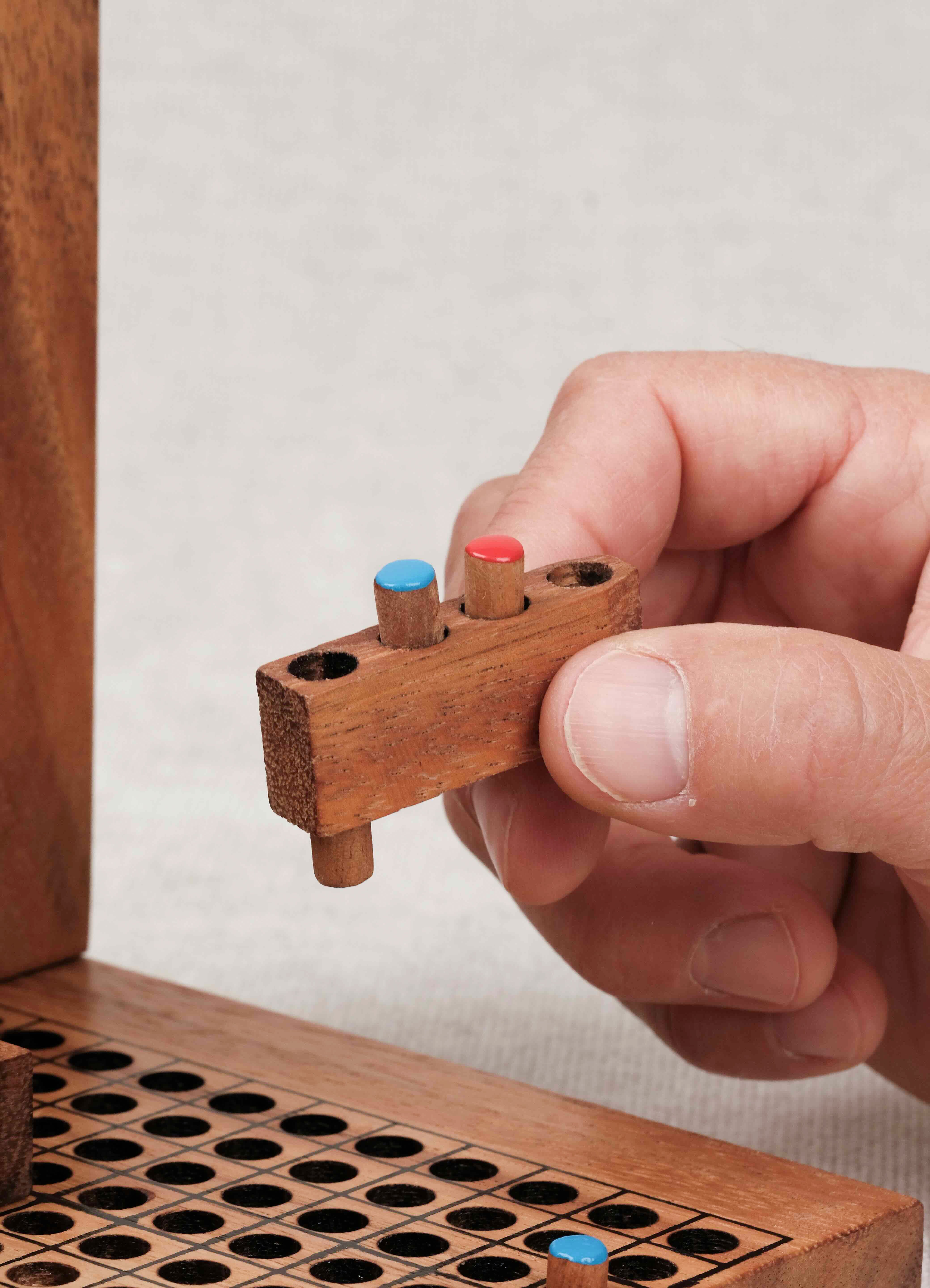 Main plaçant un pion coloré dans la grille de la bataille navale