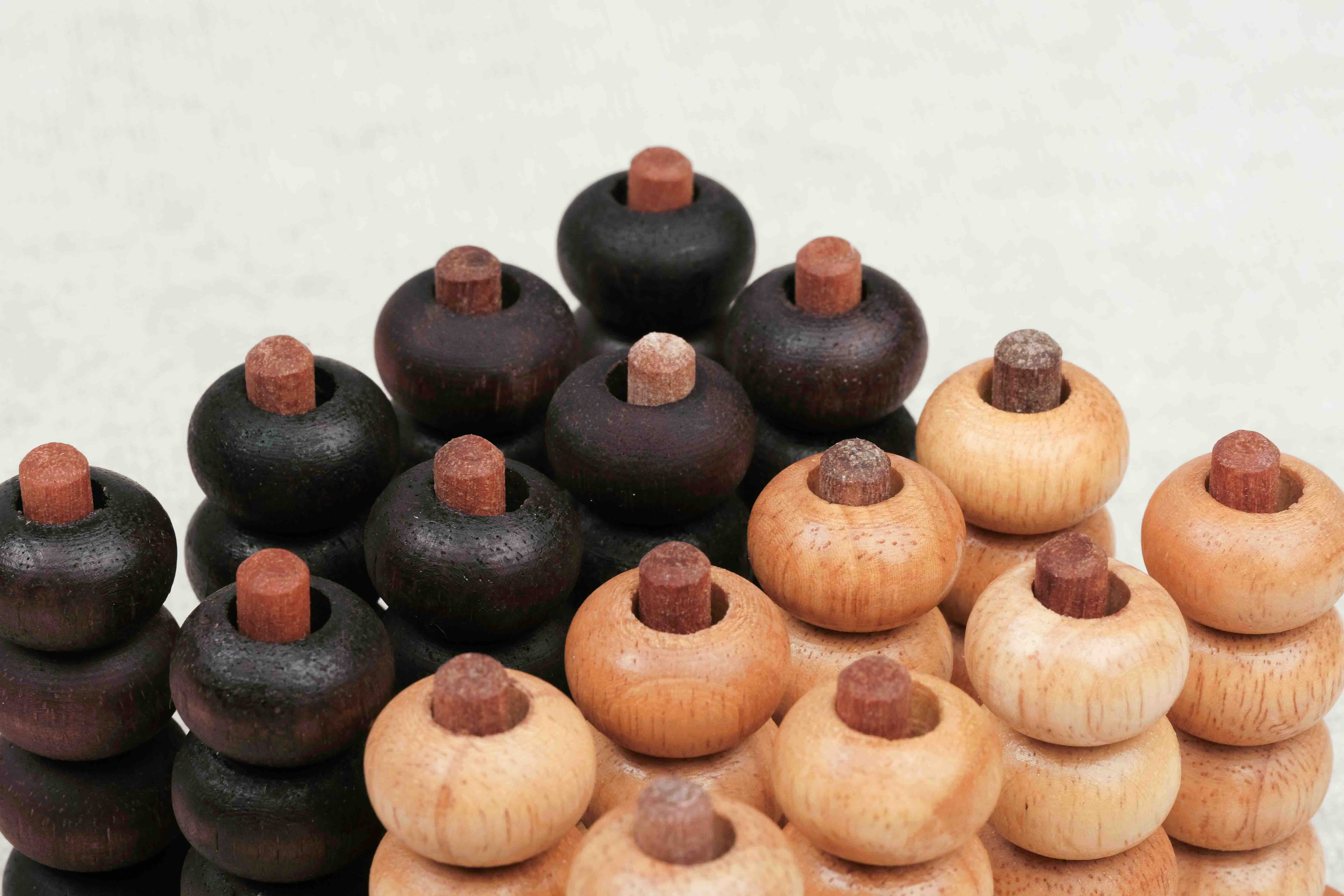 Pions en bois clair et foncé utilisés pour le jeu Puissance 4 3D