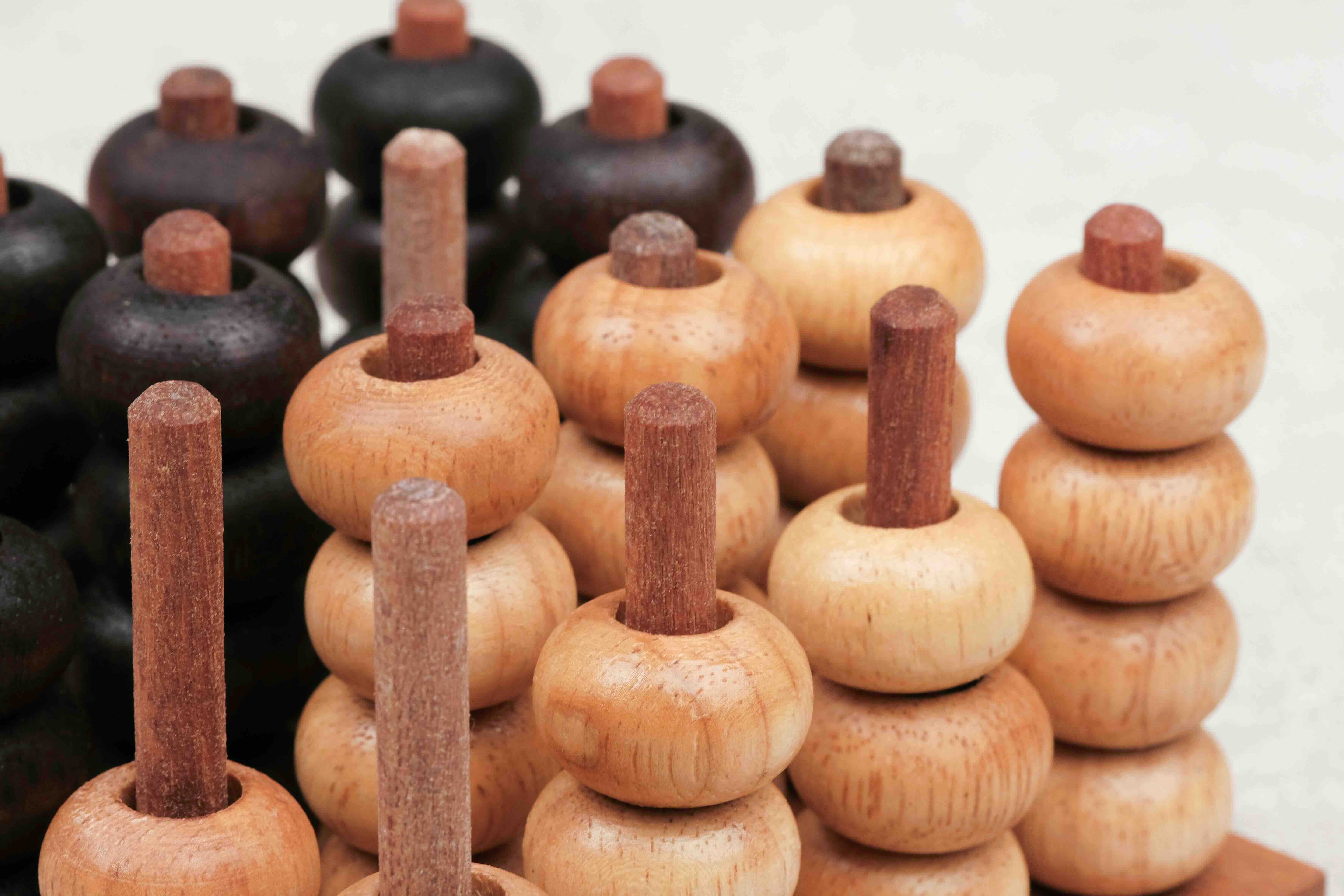 Pions en bois clair et foncé utilisés pour le jeu Puissance 4 3D