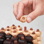 Main plaçant un pion sur la grille 3D du Puissance 5