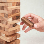 Joueur retirant une pièce de la tour Jenga en bois