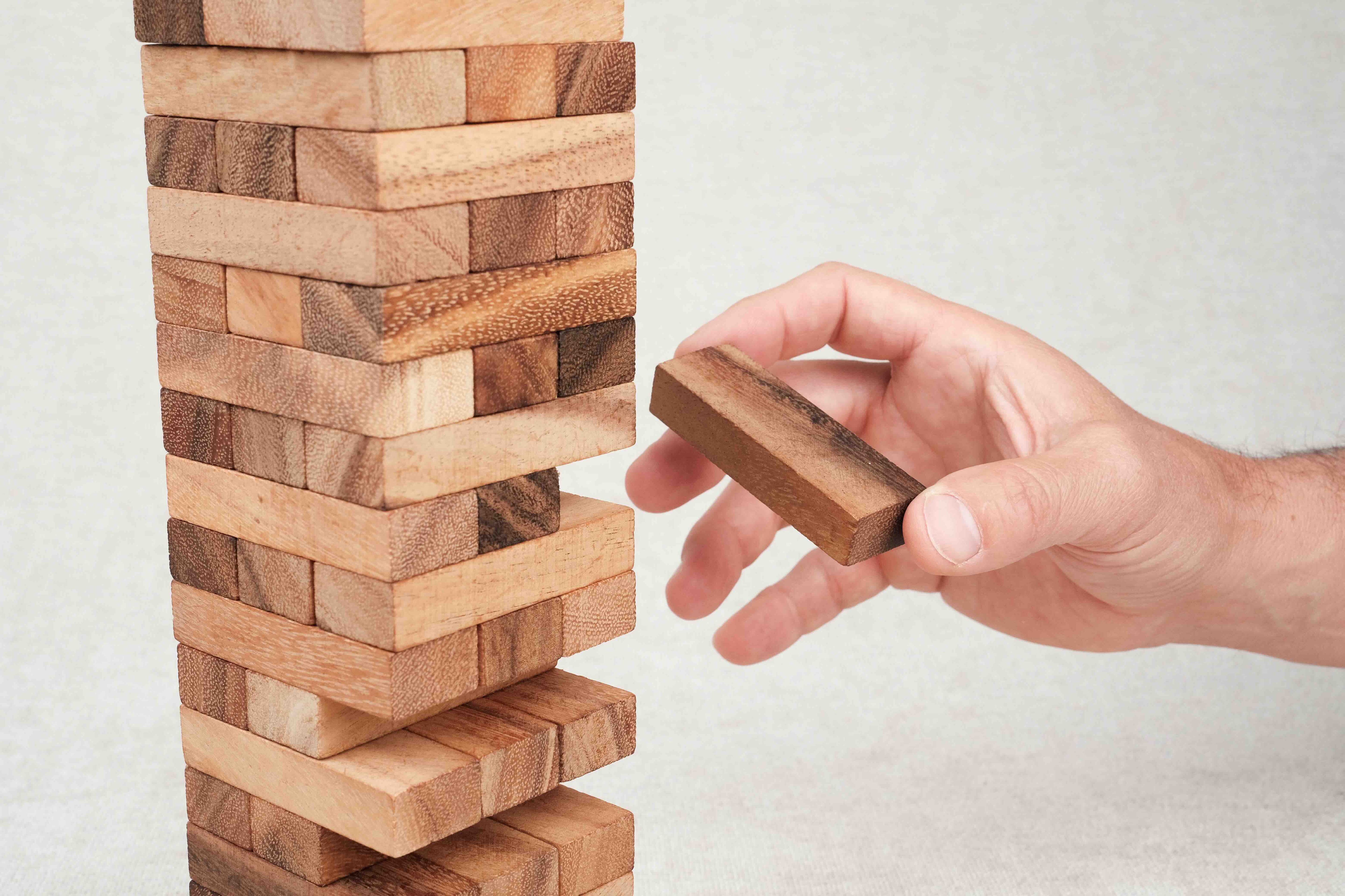 Joueur retirant une pièce de la tour Jenga en bois