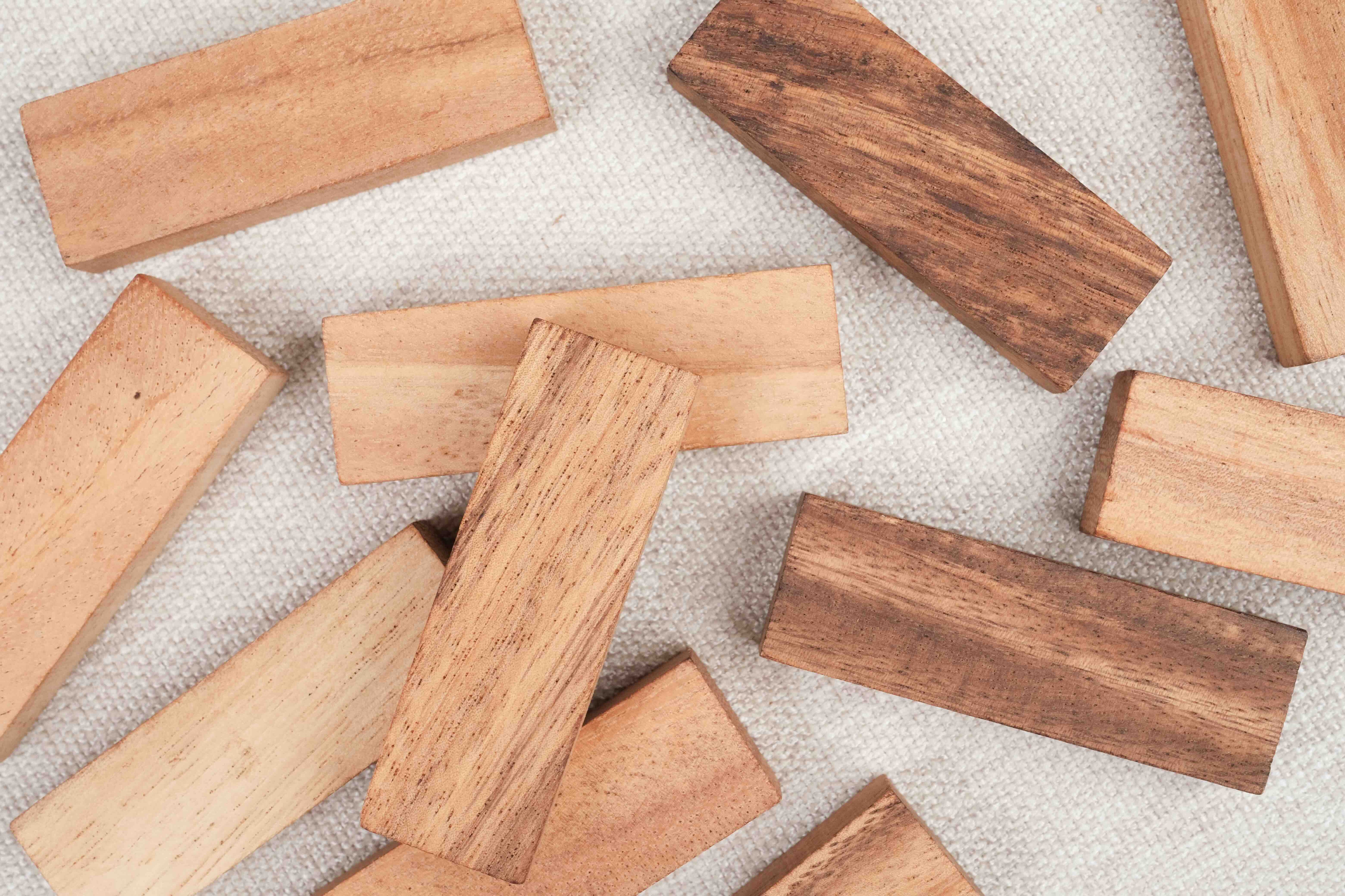 Gros plan sur les blocs de Jenga en bois massif posés en vrac su fond blanc