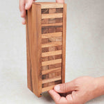 Mains formant la tour grace au coffret de rangement Jenga bois taille moyenne
