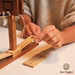 Gros plan sur la planche en bois et les cordelettes du jeu d’adresse.