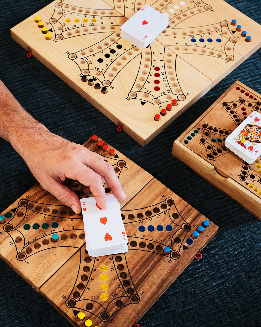 Main prenant une carte dans une vue d’ensemble des plateau de Tock  Jeux Faugère