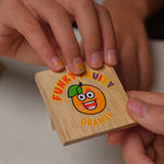 Plaquette "orange" du jeu Funky Fruity tenue à la main.