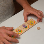 Plaquette en bois Funky Fruity avec fruits colorés tenue à la main.