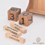 Main apprenant à composer la date avec le calendrier perpétuel en bois Jeux Faugère