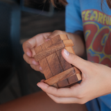 Boîte secrète S en bois Jeux Faugère tenue dans les mains d'un enfant – casse-tête adulte et enfant, idée cadeau