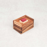 Casse-tête Mission Impossible en bois avec pièce rouge visible dans sa boîte.
