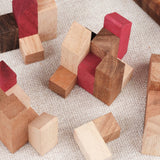 Gros plan sur les pièces colorées du casse-tête La Cité Infernale en bois imbriquées dans la base – Puzzle multi-combinaisons – Jeux Faugère