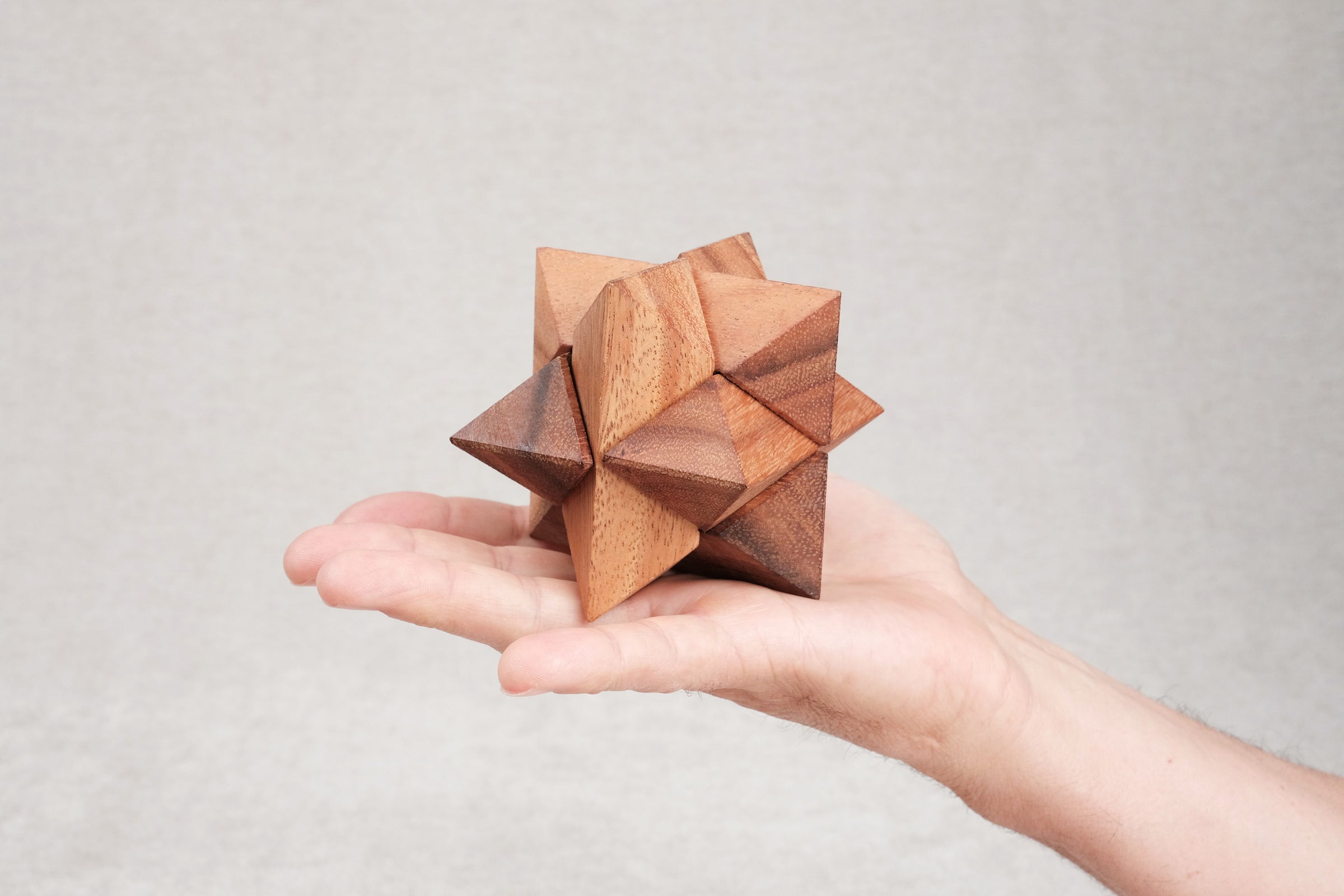 Casse-tête La Star en bois, format 8 cm, tenu dans la main.