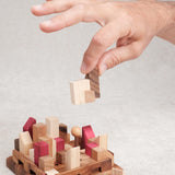 Main qui manipule une pièce du casse-tête La Cité Infernale en bois – Puzzle multi-combinaisons – Jeux Faugère