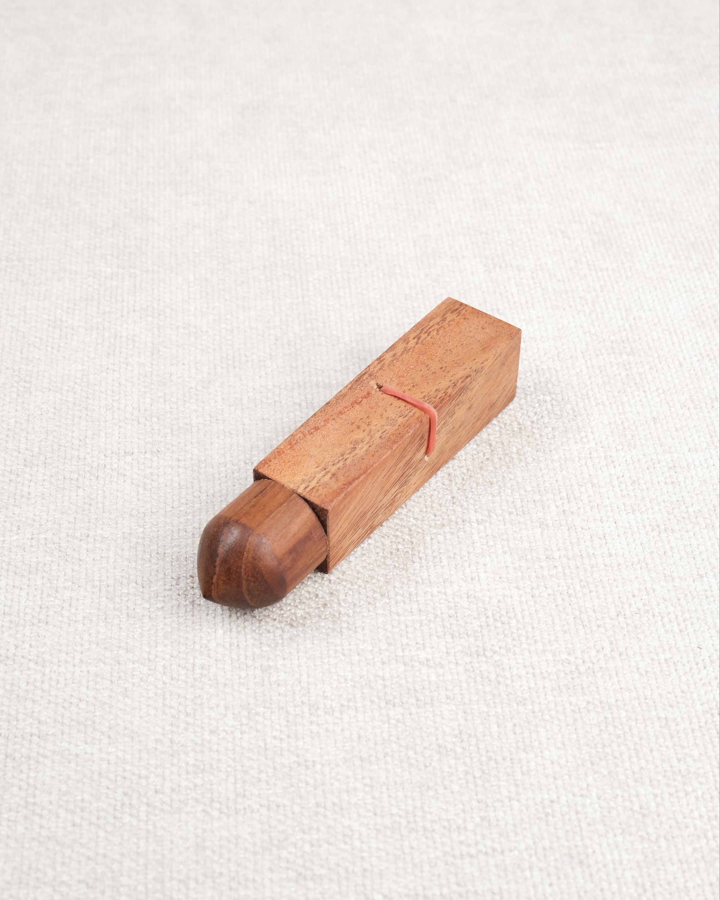 Mini casse-tête Bâtonnet du Diable en bois acacia – élastique rouge visible.