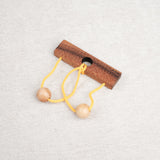 Casse-tête en bois Roméo & Juliette avec ficelle jaune et deux boules en bois.