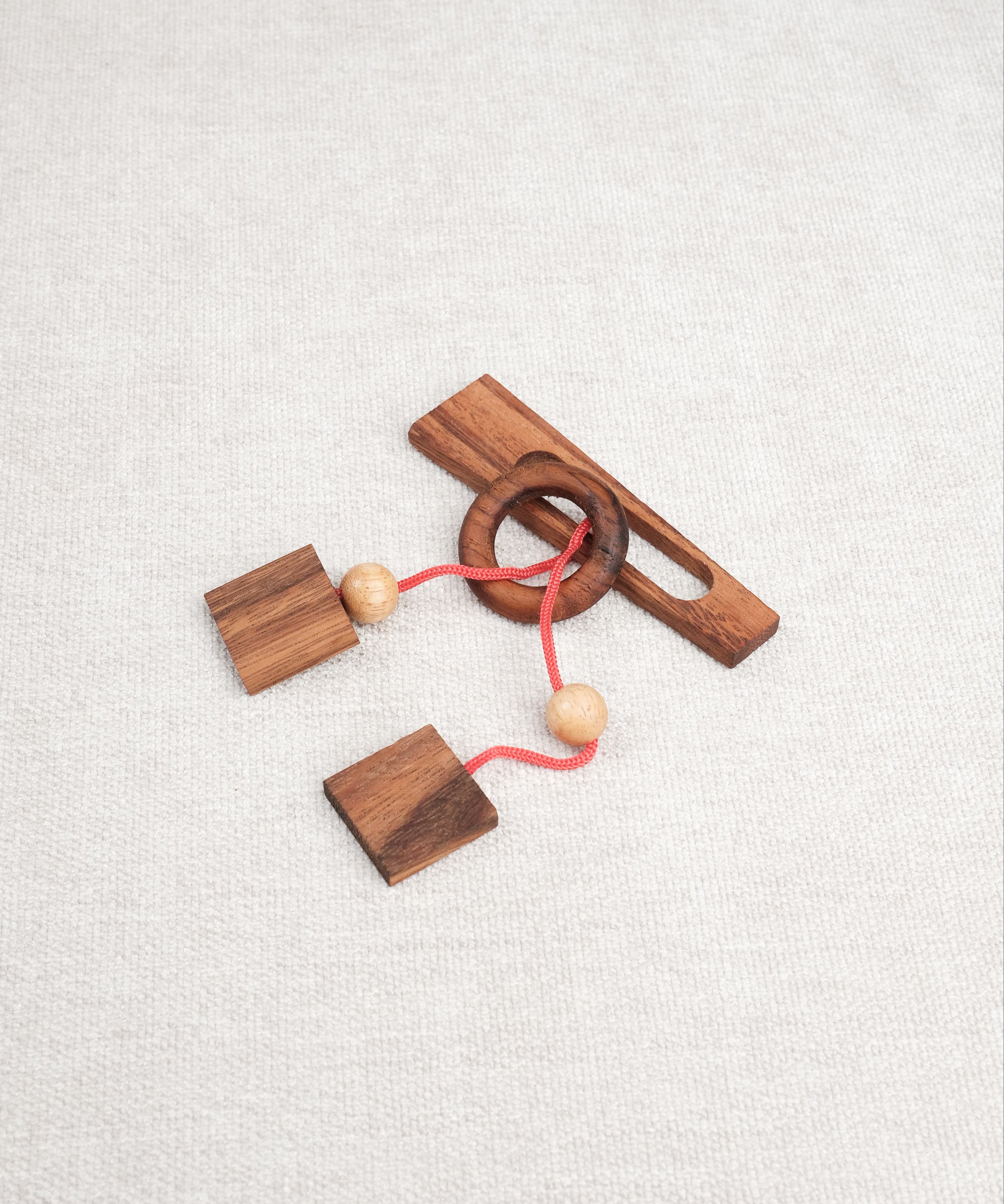 Vue du casse-tête ficelle Diapason en bois avec anneau et cordon rouge – Jeux Faugère