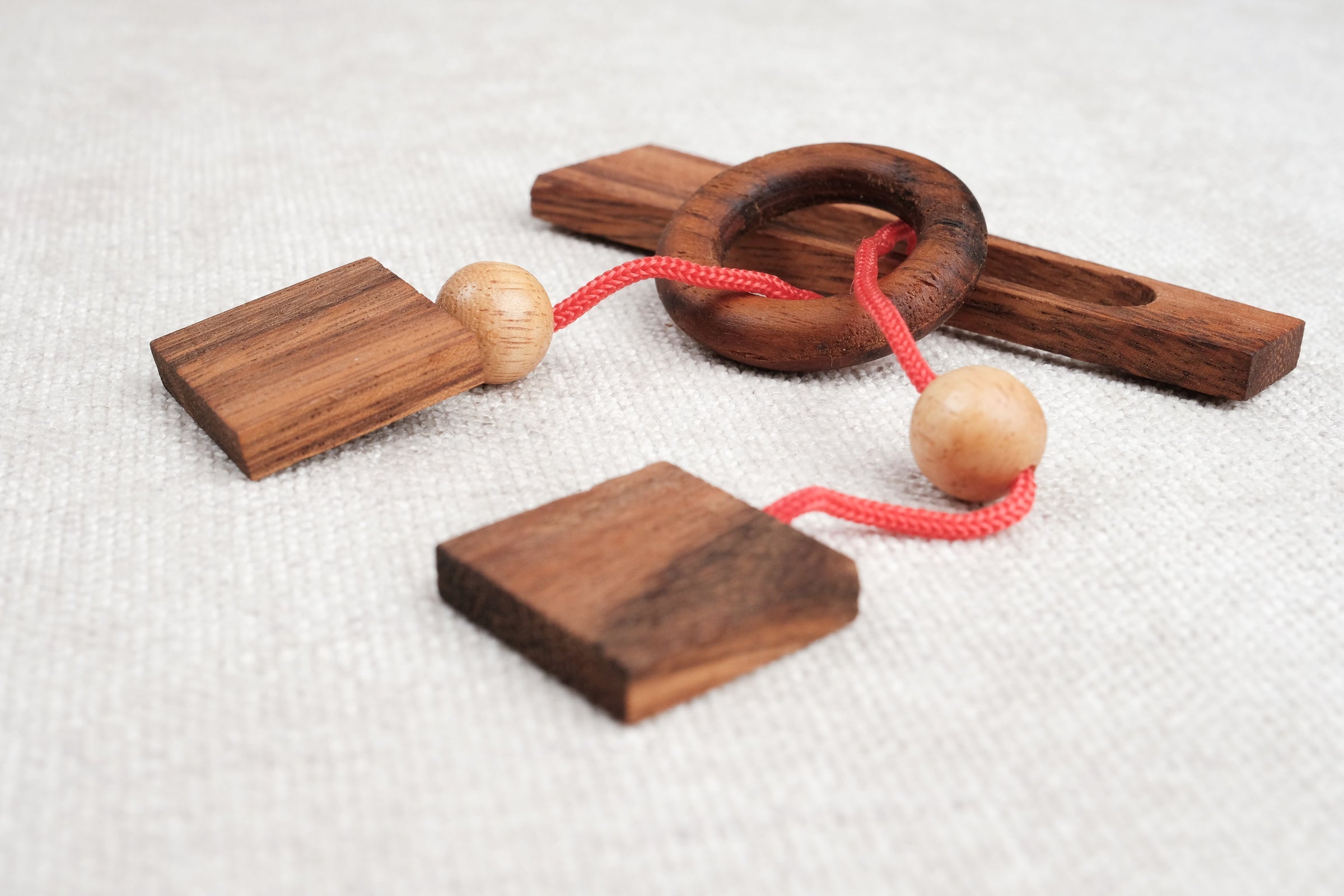 Gros plan sur le mini casse-tête Diapason en bois foncé et boules en hévéa – Jeux Faugère