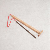 Casse-tête en bois Bozo-Bozo avec baguette et hélice reliée par une ficelle rouge.