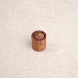 Cylindre en bois avec embout visible inséré dans un support