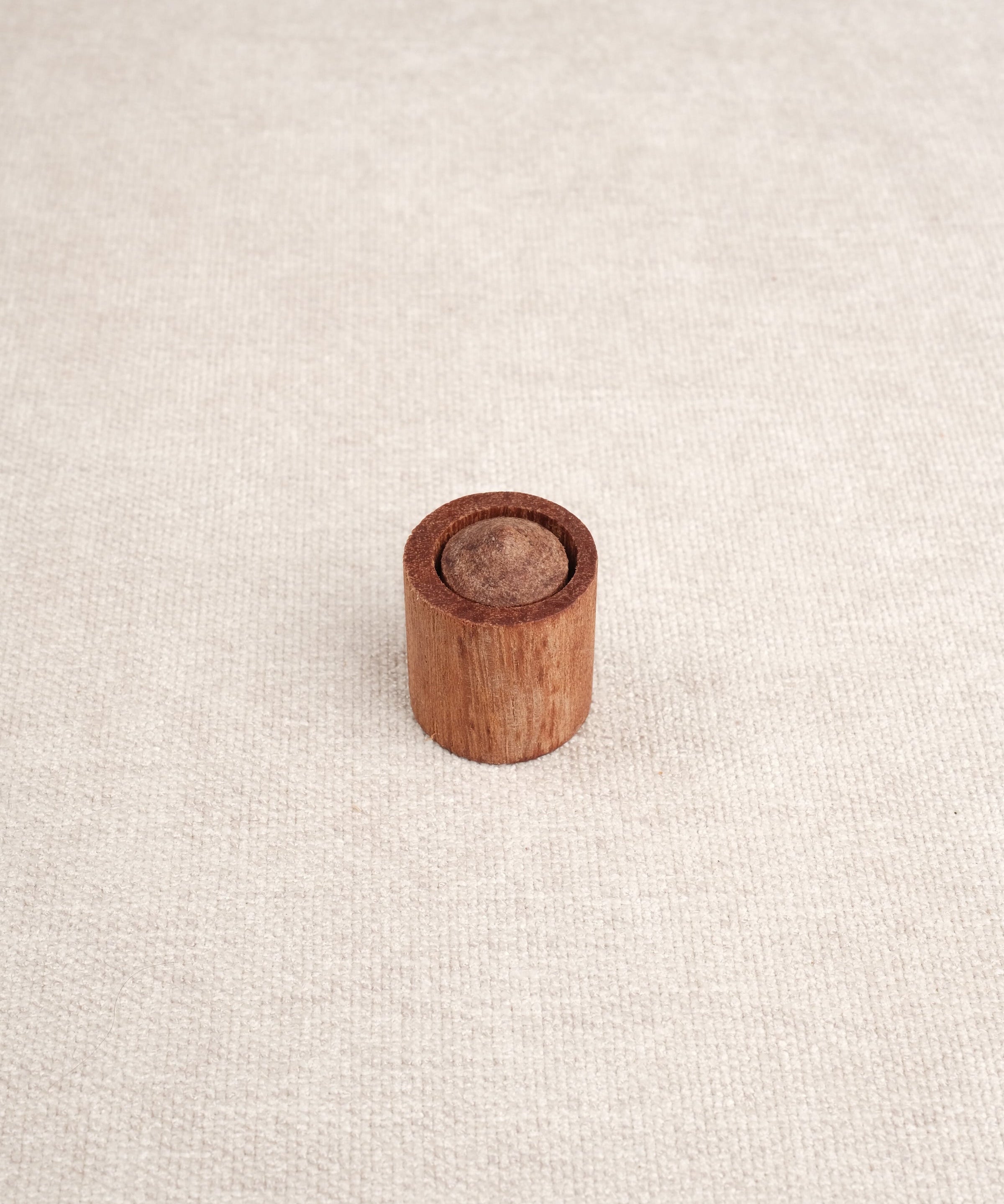 Cylindre en bois avec embout visible inséré dans un support