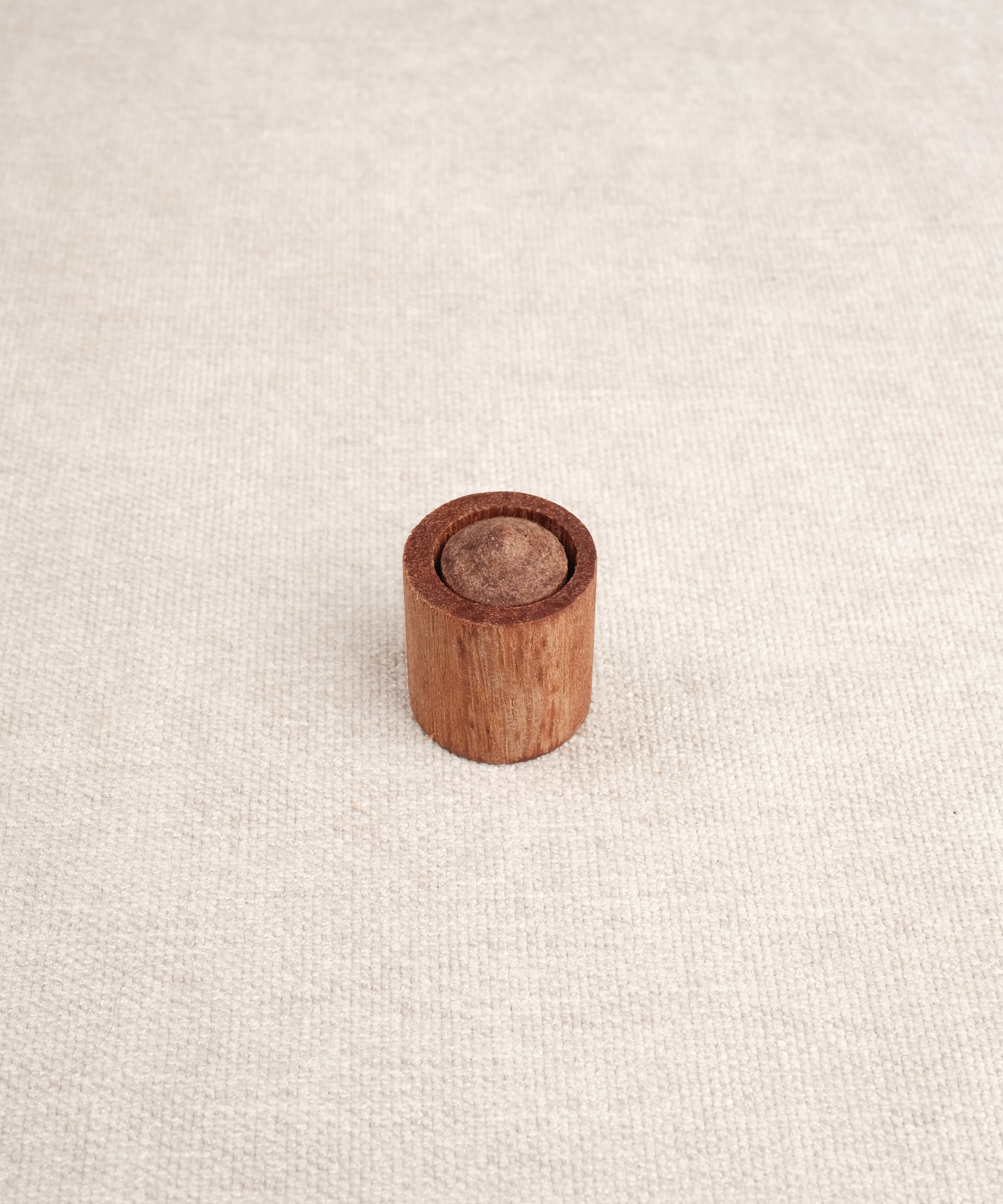 Cylindre en bois avec embout visible inséré dans un support