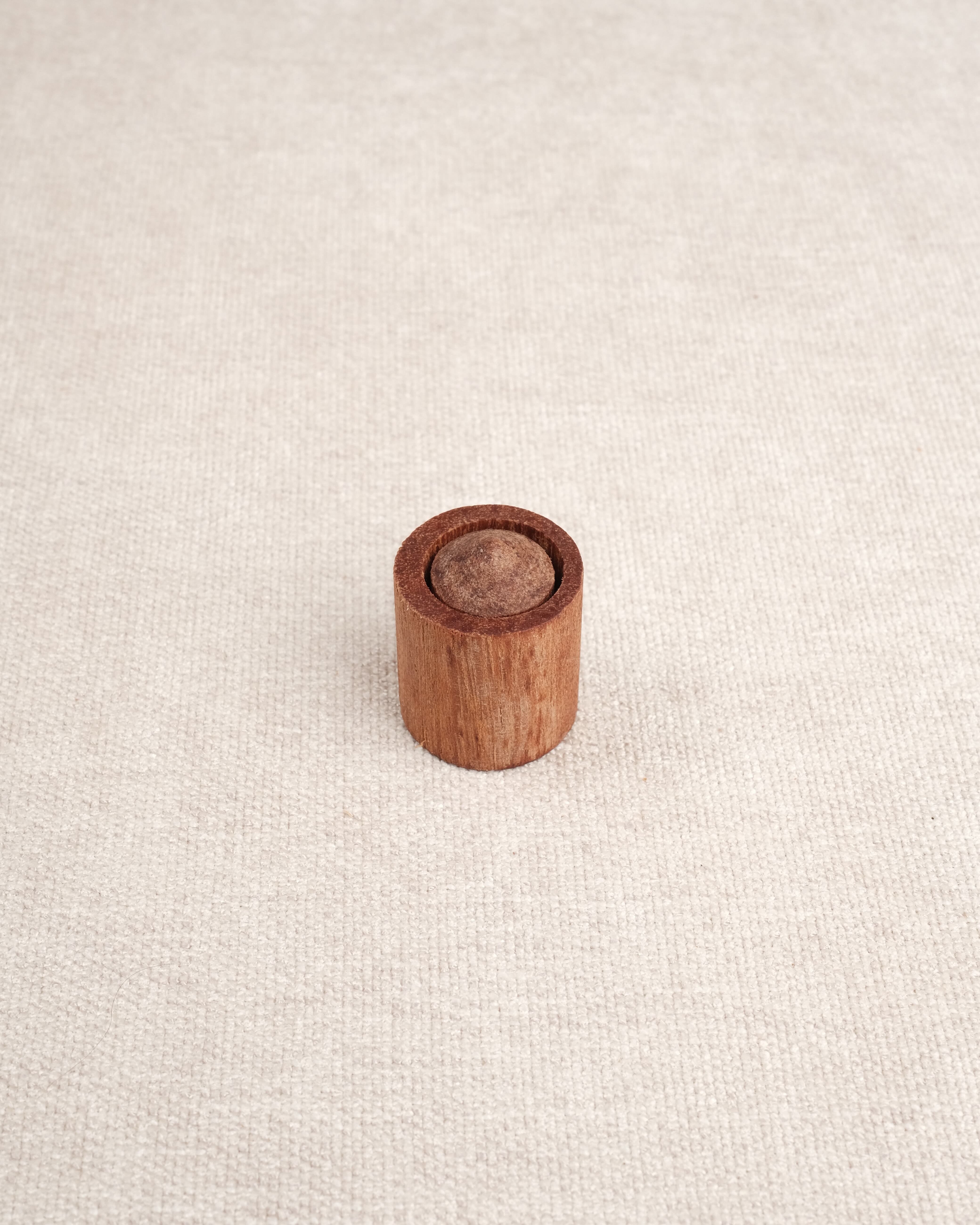 Cylindre en bois avec embout visible inséré dans un support