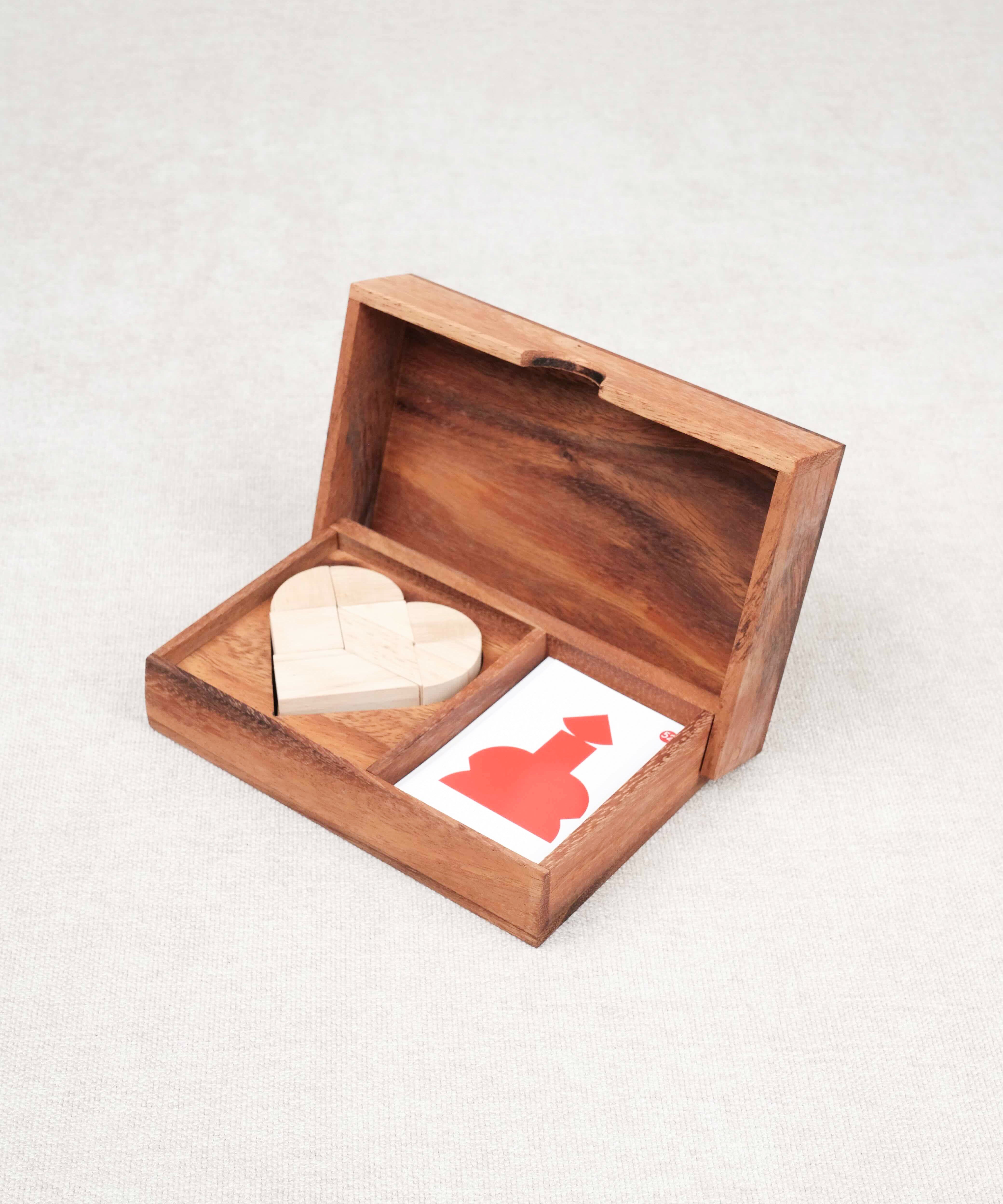 Coffret en bois ouvert contenant un tangram cœur et des cartes défis – Double Tangram Cœur Jeux Faugère